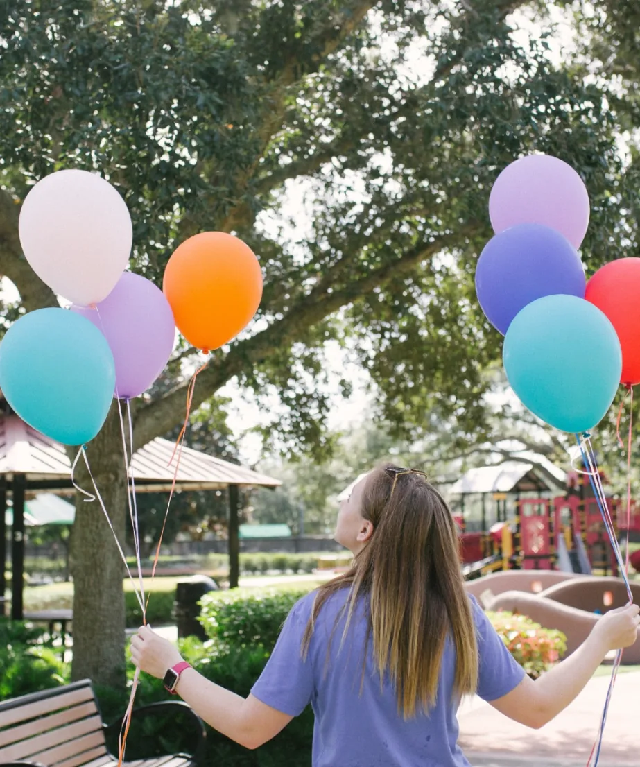 A Carilly sitter holding bunches of balloons at a Lakeland playground